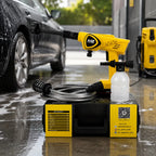 Yellow and black pressure washer kit with a hose, bottle, and base unit shown outdoors beside a wet car, with a second unit in the background.