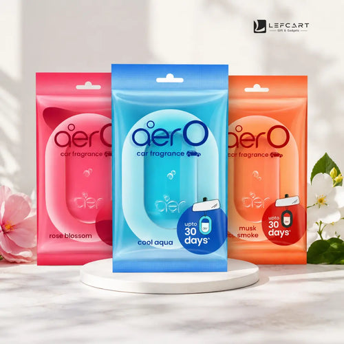 Three aero car fragrance air freshener pouches displayed on a white pedestal. The center pouch is blue and labeled 'cool aqua', flanked by pink 'rose blossom' and orange 'musk smoke' pouches, with decorative flowers on both sides.